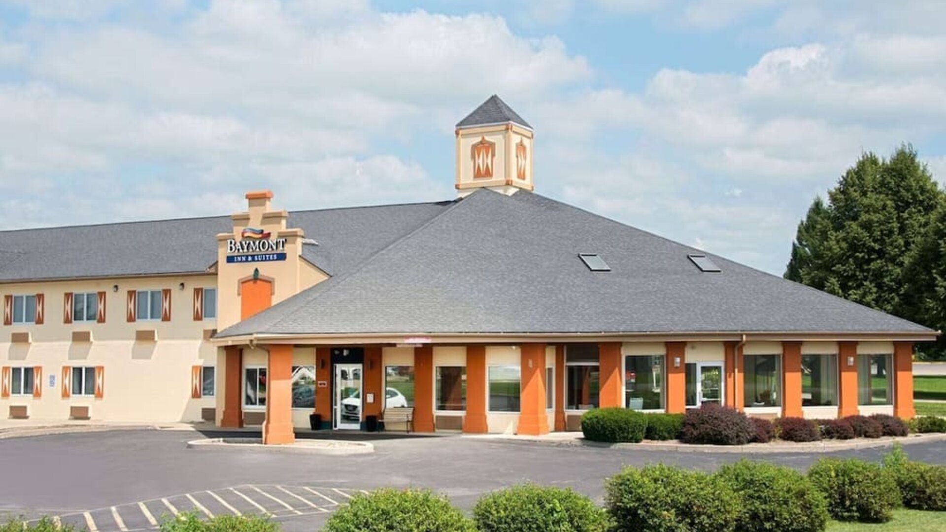 Parking and hotel exterior at Baymont By Wyndham Pella.