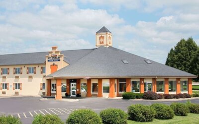 Parking and hotel exterior at Baymont By Wyndham Pella.