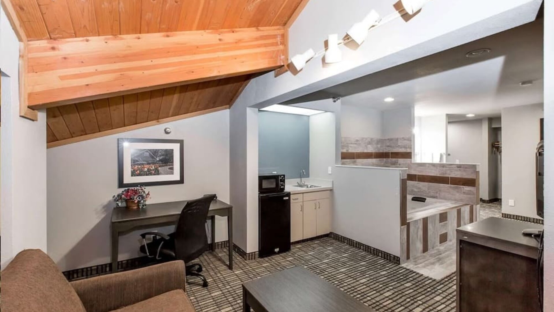 Day room with kitchen and lounge area at Baymont By Wyndham Pella.