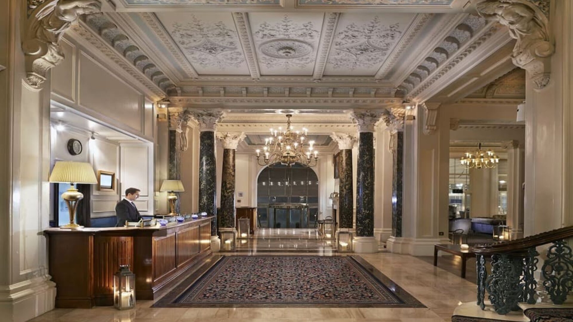 Reception area with elegant architectural details and decorative chandeliers at The Grand Brighton. 