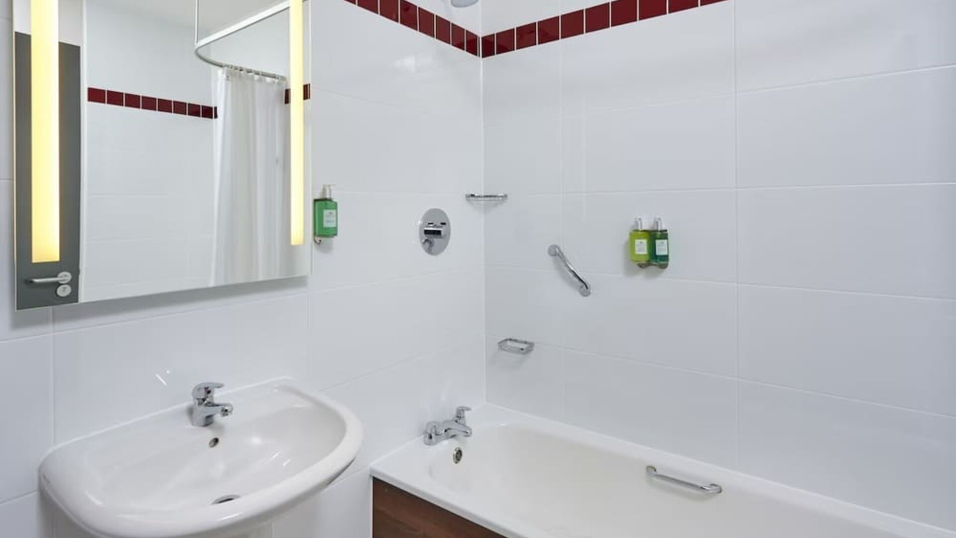 Guest bathroom with shower and tub at Leonardo Hotel Milton Keynes.