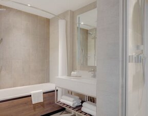Guest bathroom with shower and tub at Hilton Edinburgh Carlton.