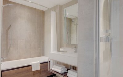 Guest bathroom with shower and tub at Hilton Edinburgh Carlton.