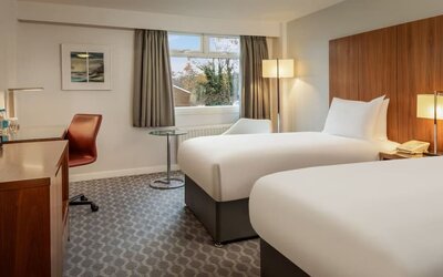 Day use room with double bed, work desk and TV at Hilton London Watford.