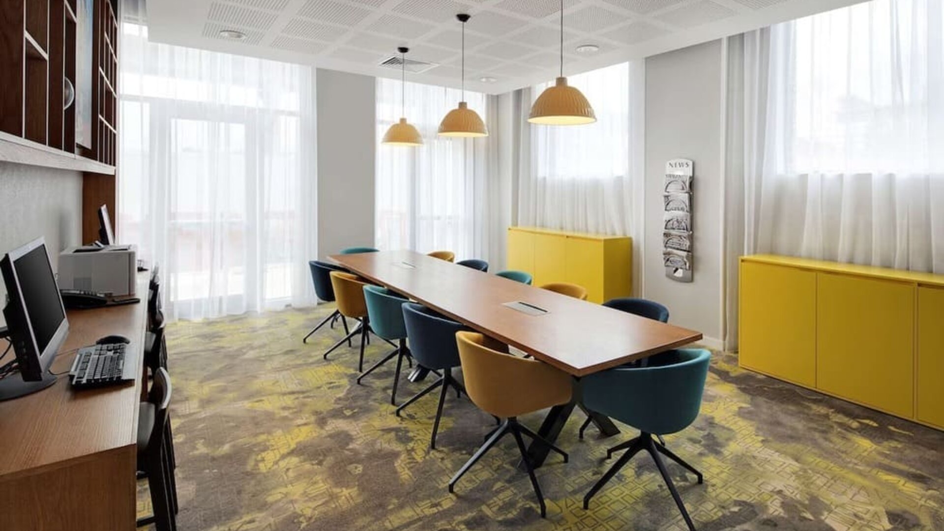 Business center with table, computer and printer at the Hampton by Hilton London Docklands.