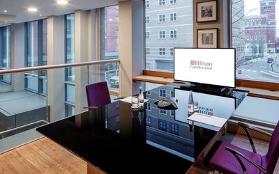 Meeting room with TV and large windows at the Hilton Garden Inn Birmingham Brindleyplace.