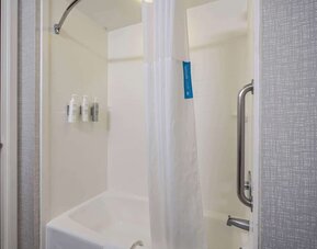 Accessible walk-in shower featuring grab bars, handheld showerhead, and convenient entry designed for a comfortable stay at Hampton Inn Ridgefield Park.