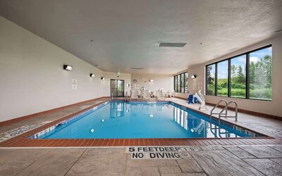 Spacious indoor pool offering a refreshing environment with ample natural light and comfortable seating for guests at Hampton Inn Ridgefield Park.