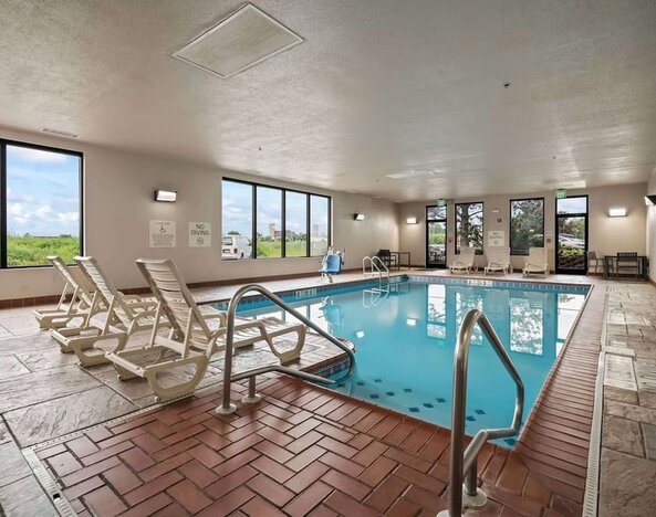 Spacious indoor pool offering a refreshing environment with ample natural light and comfortable seating for guests at Hampton Inn Ridgefield Park.