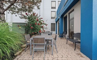 Outdoor patio featuring comfortable seating, landscaped surroundings, and a peaceful space to relax and unwind at Hampton Inn Ridgefield Park.