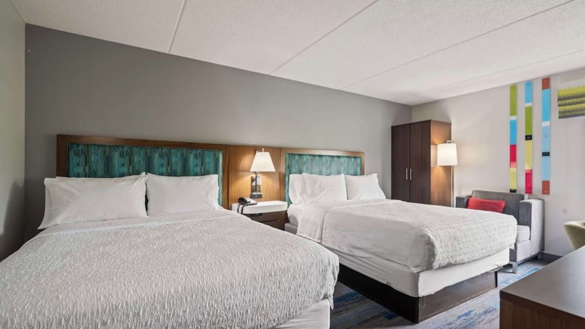 Double Queen guest room featuring two plush beds, modern décor, spacious accommodations, and comfortable amenities for families and groups.