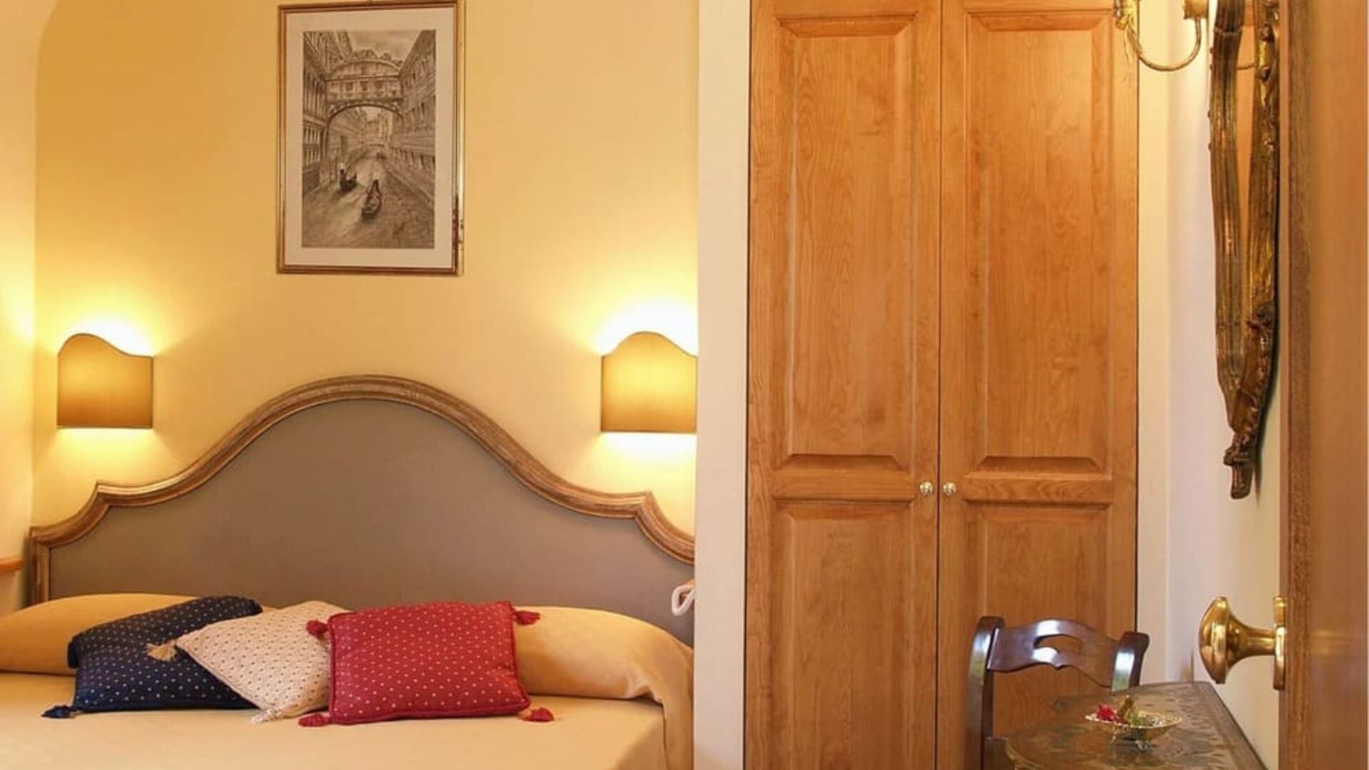 Bright and elegant guest room featuring a comfortable double bed, classic furnishings, and a writing desk.