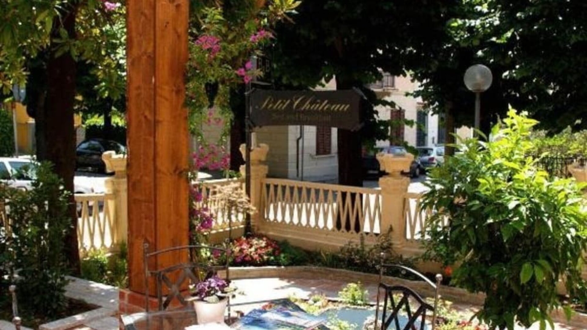 Peaceful outdoor terrace with garden seating surrounded by lush greenery, perfect for enjoying breakfast or relaxing outdoors.