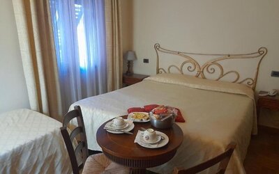 Spacious guest room with one double bed and one single bed, ideal for families or small groups.