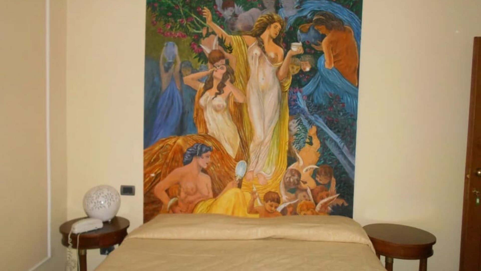 Comfortable guest room featuring a double bed, classic furnishings, and a striking decorative artwork.