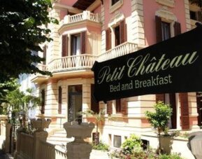 Exterior view of Petit Chateau showcasing its elegant villa architecture, landscaped gardens, and welcoming entrance.