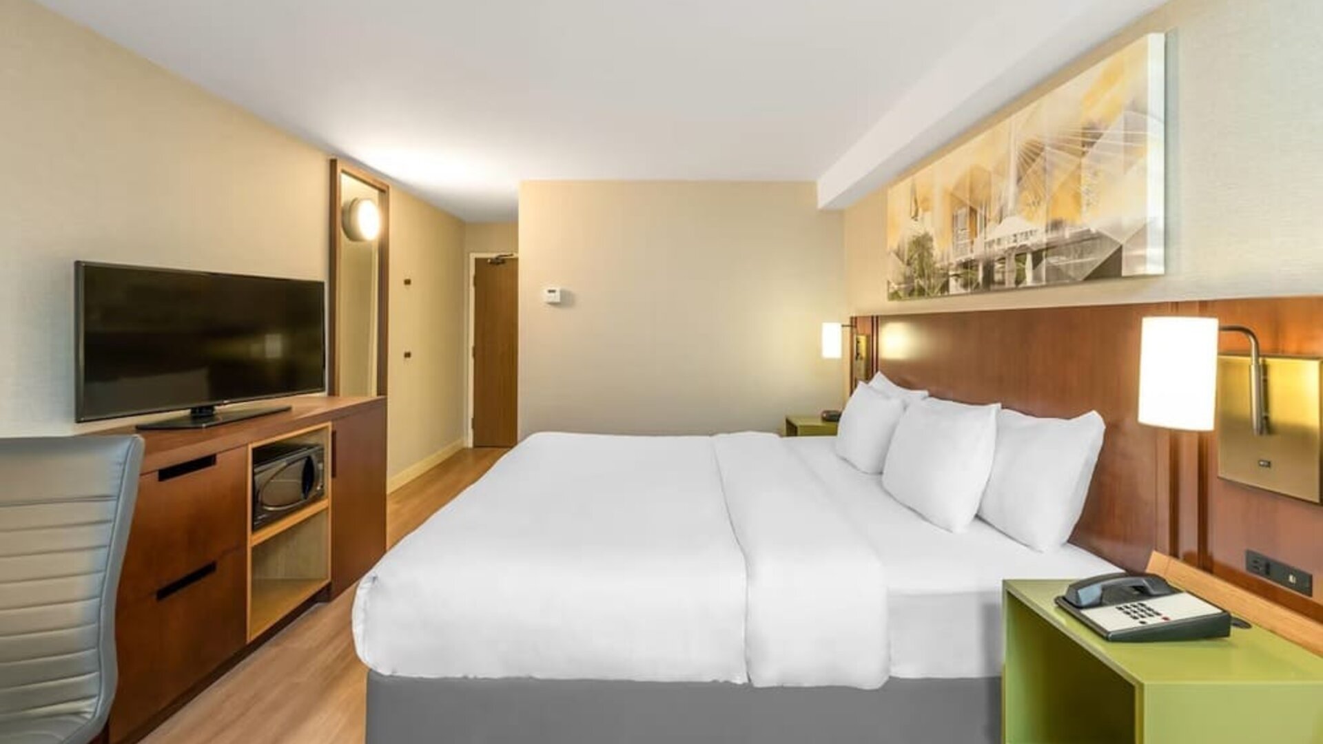 King guest room with work desk, flat-screen TV, microwave, and contemporary furnishings at Comfort Inn Boucherville.