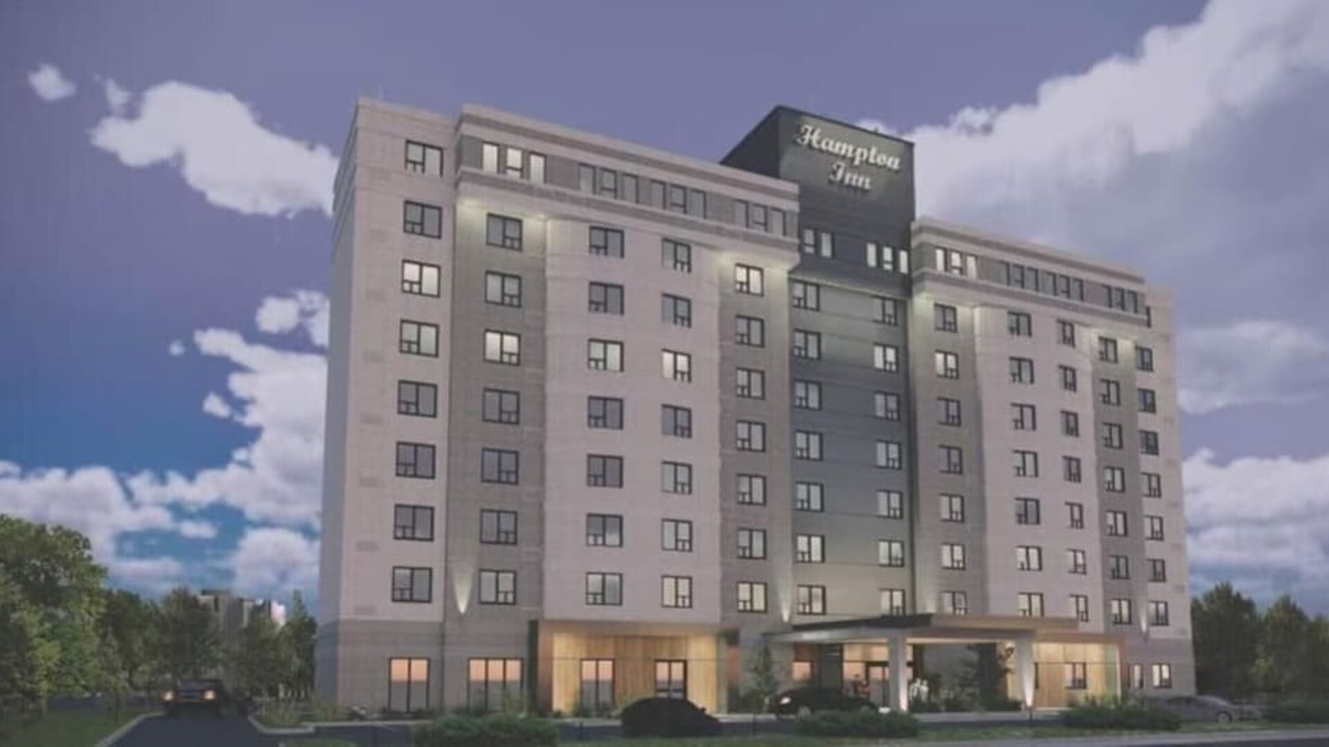 Contemporary hotel exterior with covered entrance and illuminated Hampton Inn signage at Hampton Inn By Hilton Montreal East Anjou.