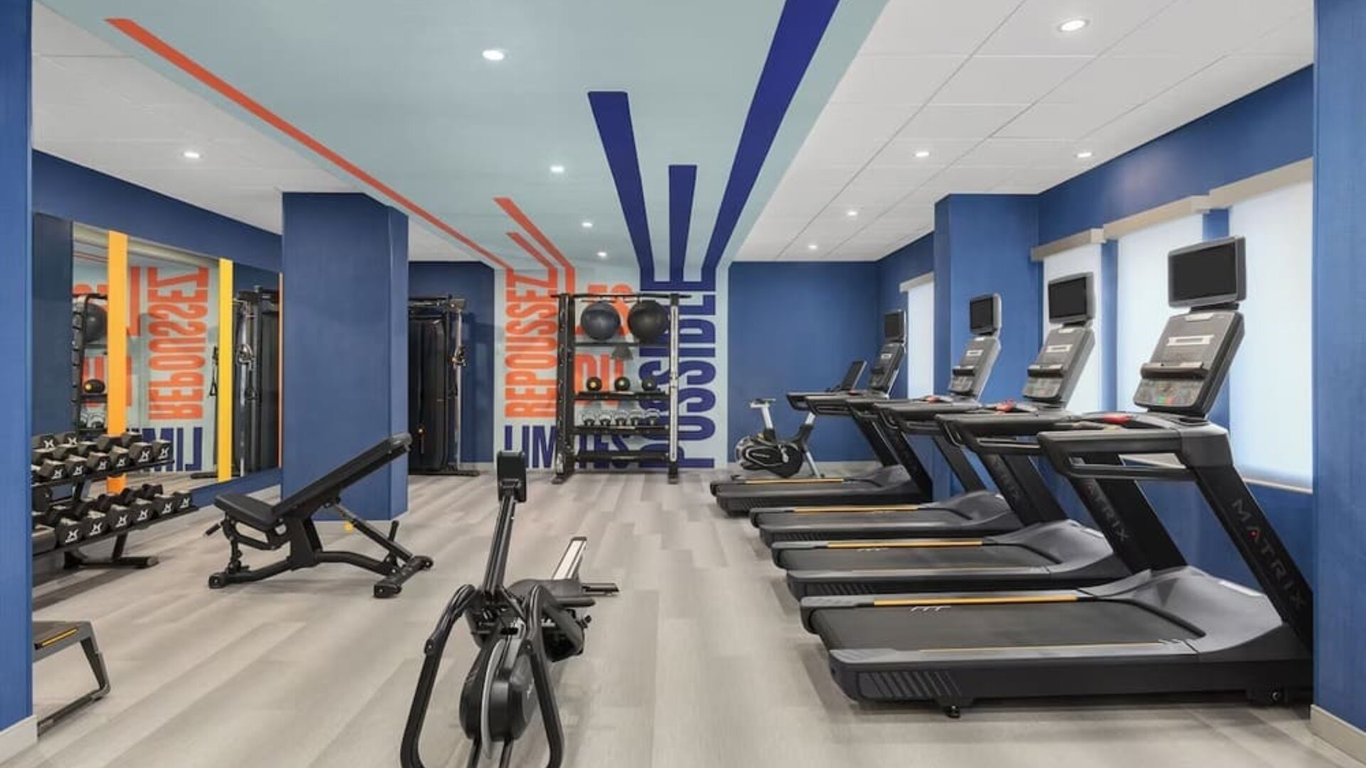 Spacious fitness room with treadmills, rowing machine, weight bench, and strength training equipment at Hampton Inn By Hilton Montreal East Anjou.