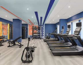 Spacious fitness room with treadmills, rowing machine, weight bench, and strength training equipment at Hampton Inn By Hilton Montreal East Anjou.