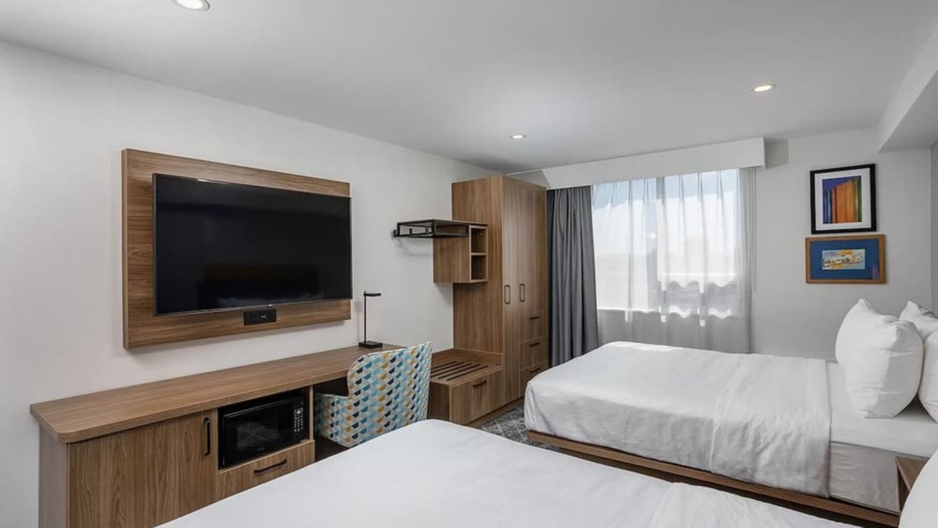 Guest room with two queen beds, large television, work desk, and wood furnishings at Hampton Inn By Hilton Montreal East Anjou.