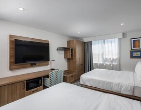 Guest room with two queen beds, large television, work desk, and wood furnishings at Hampton Inn By Hilton Montreal East Anjou.