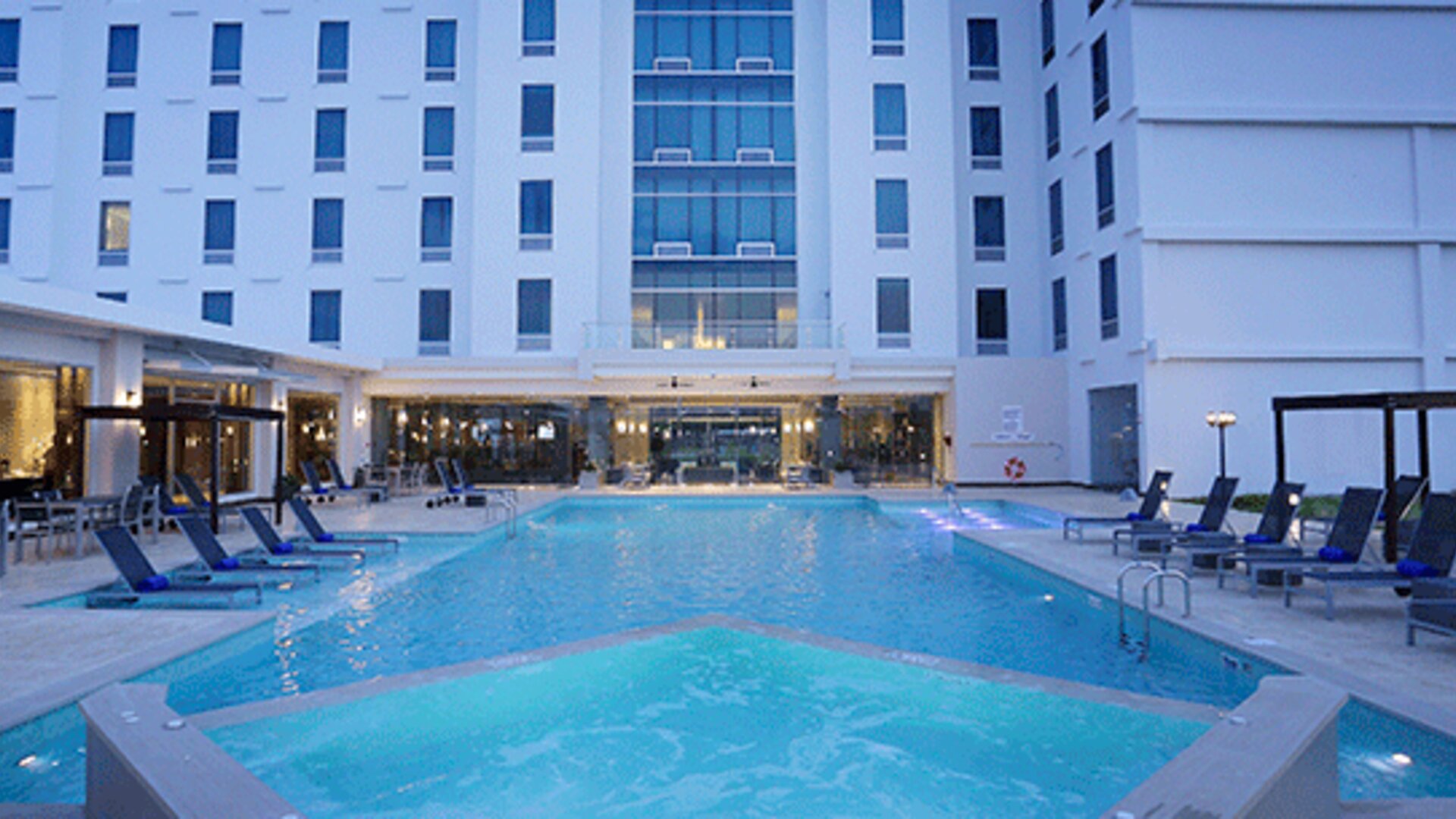 Expansive outdoor pool complex with sun loungers, cabanas, and resort-style amenities available to guests at Crowne Plaza Panama Airport.