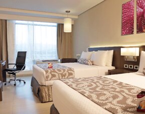 Bright and spacious double guest room featuring two beds, work-friendly amenities, and contemporary furnishings at Crowne Plaza Panama Airport.