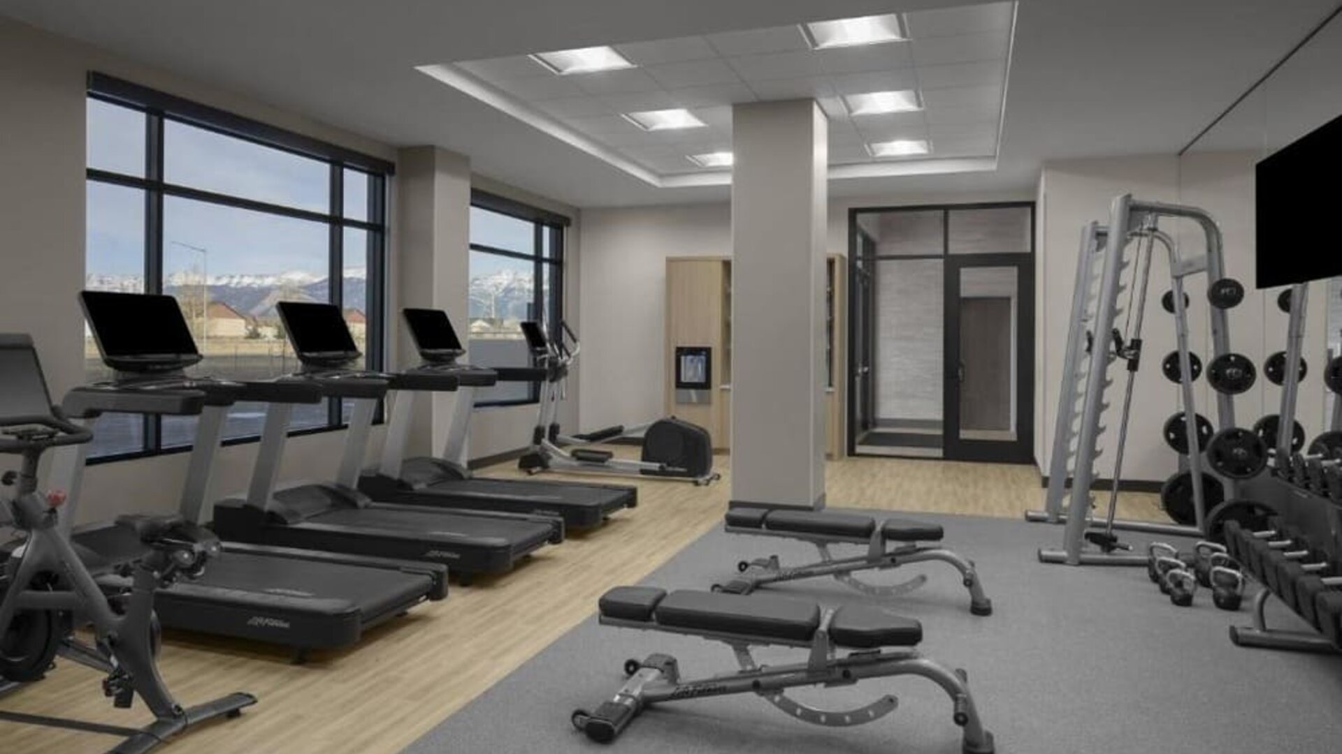 Fitness center with treadmills, free weights, benches, and strength training equipment at Hyatt Place Bozeman Yellowstone Airport.