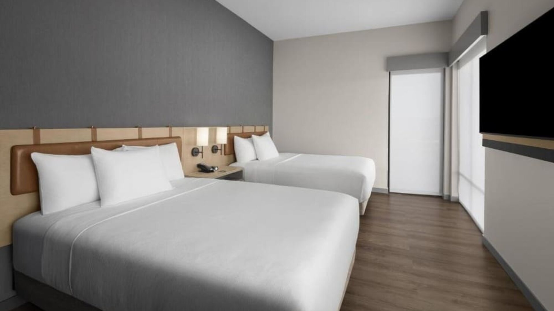Guest room with two queen beds, contemporary décor, and wall-mounted television at Hyatt Place Bozeman Yellowstone Airport.