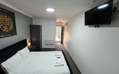 King guest room with comfortable bed, flat-screen television, and contemporary furnishings at Stay Inn Express.