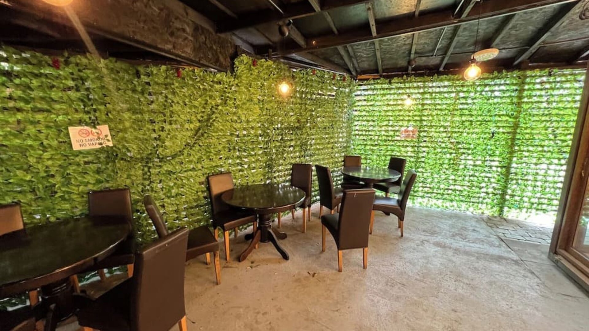 Outdoor covered seating area with tables and chairs for guest relaxation at Stay Inn Express.