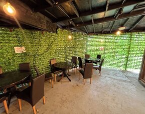 Outdoor covered seating area with tables and chairs for guest relaxation at Stay Inn Express.