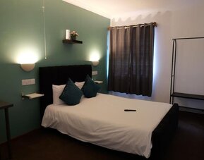 Guest room with double bed, accent wall, and modern furnishings at Stay Inn Express.