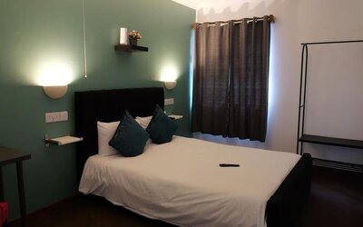 Guest room with double bed, accent wall, and modern furnishings at Stay Inn Express.