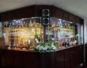 Hotel bar with a selection of spirits, wine, and glassware at Stay Inn Express.