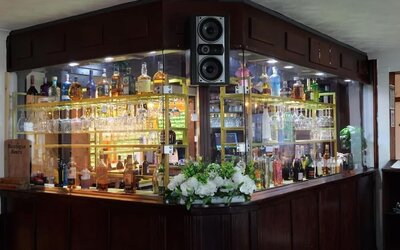 Hotel bar with a selection of spirits, wine, and glassware at Stay Inn Express.