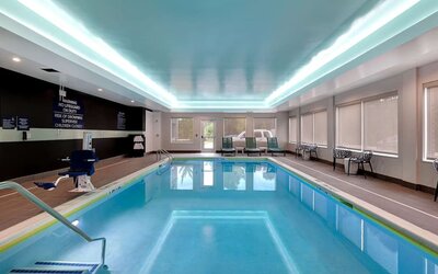 ndoor swimming pool with lounge seating and accessible amenities at Tru By Hilton Lithia Springs.