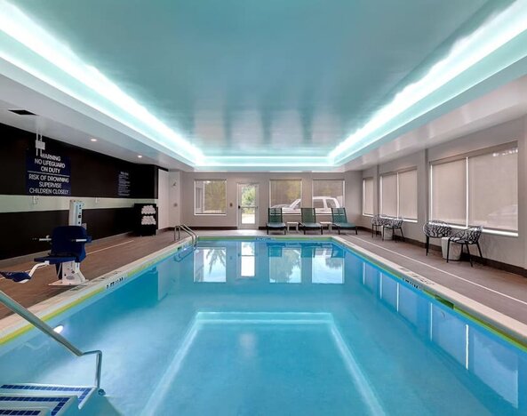 ndoor swimming pool with lounge seating and accessible amenities at Tru By Hilton Lithia Springs.