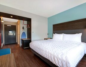 Bright king guest room with comfortable bed, workspace, and contemporary furnishings at Tru By Hilton Lithia Springs.