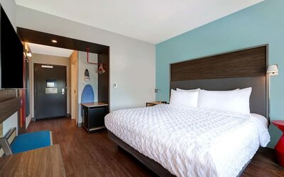 Bright king guest room with comfortable bed, workspace, and contemporary furnishings at Tru By Hilton Lithia Springs.