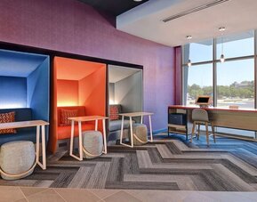 Business center with private work pods, desks, and large windows at Tru By Hilton Lithia Springs.