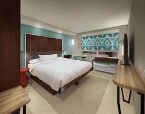 King guest room with plush bedding, work desk, and modern décor at Tru By Hilton Lithia Springs.