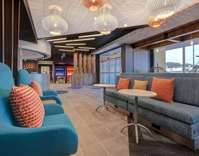 Stylish lobby lounge with modern seating, designer lighting, and inviting social spaces at Tru By Hilton Lithia Springs.