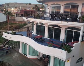 Exterior view of the multi-level beachfront resort featuring private balconies and outdoor terraces at Casa Playa Baja Resort.