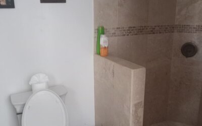 Bathroom with walk-in stone shower, toilet, and modern fixtures at Casa Playa Baja Resort.