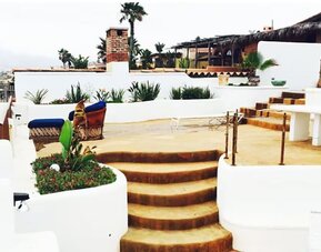Oceanfront terrace with lounge seating, outdoor dining area, and coastal views at Casa Playa Baja Resort.