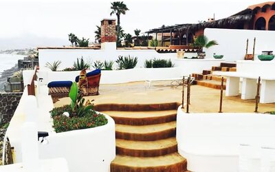 Oceanfront terrace with lounge seating, outdoor dining area, and coastal views at Casa Playa Baja Resort.