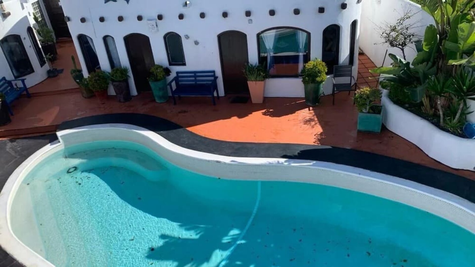 Outdoor swimming pool surrounded by resort accommodations and tropical landscaping at Casa Playa Baja Resort.
