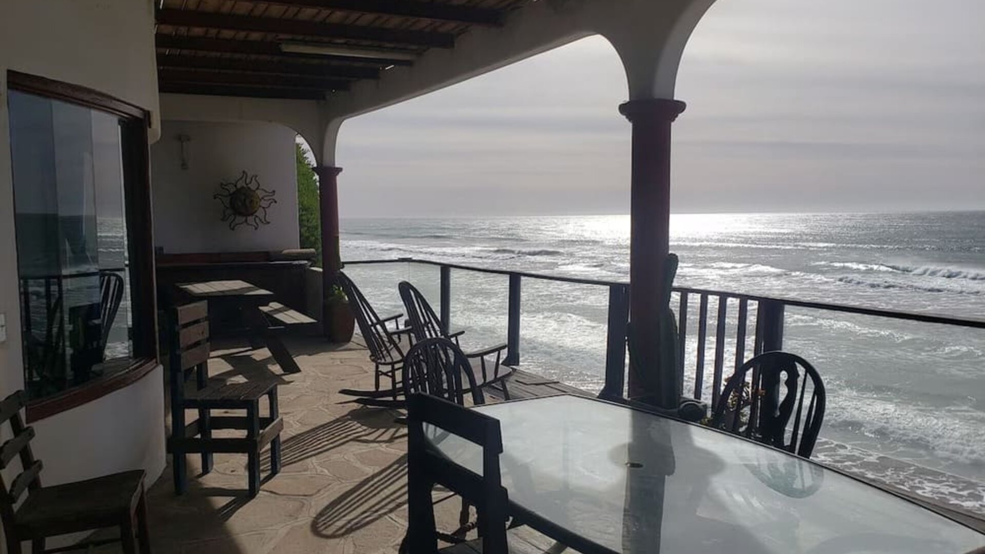 Covered beachfront terrace with outdoor dining and unobstructed ocean views at Casa Playa Baja Resort.